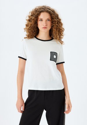 Hvid T-shirt med korte ærmer, sort ribbet halsudskæring og manchetter, der har en kvadratisk broderet lomme detalje på venstre bryst.