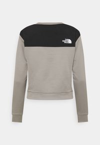Felpa grigia e nera con un corpo texturizzato, spalle nere uniformi e un logo bianco sul retro. Presenta polsini e orlo a coste.