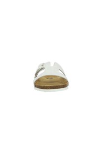 Sandale en cuir blanc à enfiler avec bout ouvert et deux sections découpées. Elle présente une boucle en argent et une semelle en liège. La semelle est texturée.