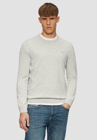 Lichtgrijze crewneck sweatshirt van textuurstof, met ribgebreide manchetten en zoom, gedragen over een wit T-shirt, gecombineerd met blauwe jeans.
