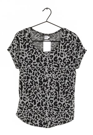 Grijs T-shirt met korte mouwen en zwarte luipaardvlekken, hangend aan een zwarte metalen hanger tegen een witte achtergrond.