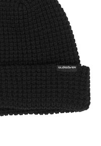 Gorro de punto negro con textura acanalada y un puño doblado. Presenta una pequeña etiqueta con el logo de Quiksilver en el lateral.