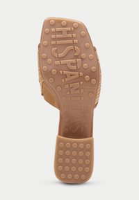 Semelle de chaussure marron clair avec caoutchouc texturé et grips circulaires. Nom de marque notable en relief ; fabriqué en Espagne.