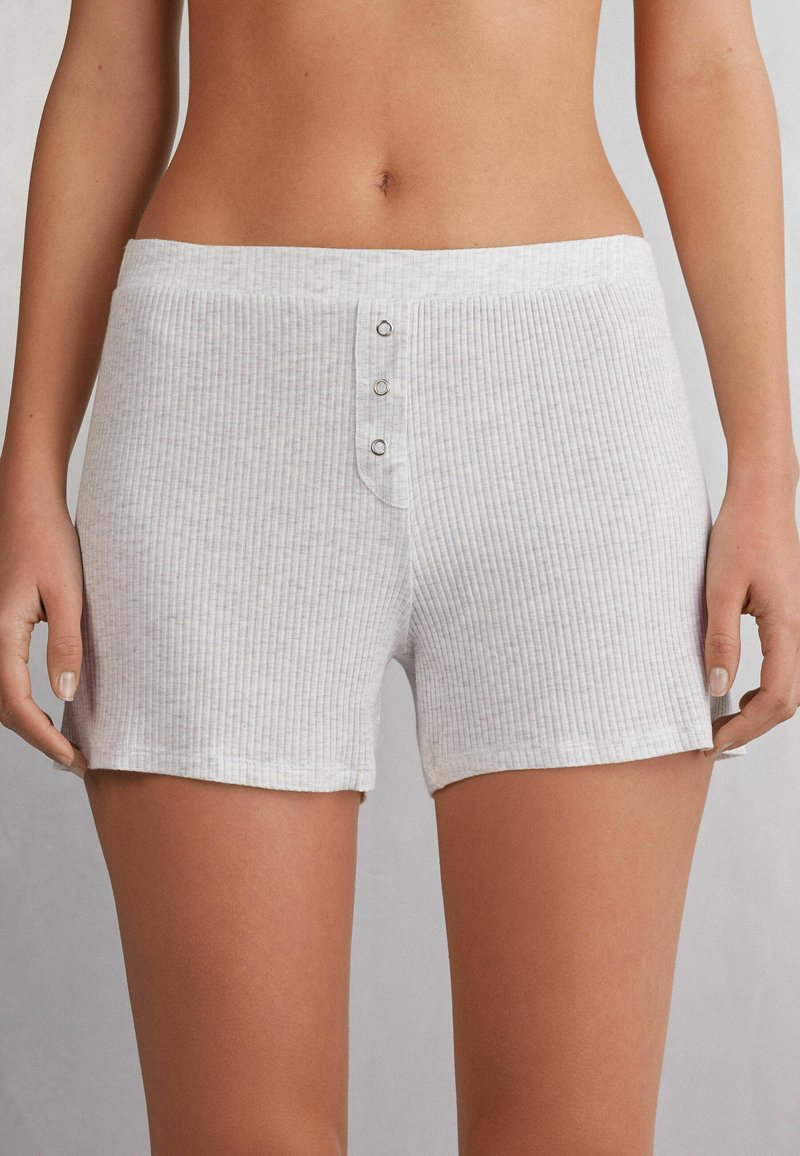 Lichtgrijze geribde shorts van zacht materiaal, met een knoopsluiting aan de voorkant met drie zilveren knopen en een comfortabele elastische tailleband.