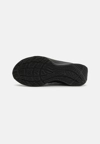 Black athletic shoe sole featuring a textured tread pattern, designed for grip with channels and grooves for flexibility and traction.