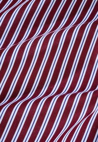 Gewebter Stoff mit schmalen roten und weißen Streifen sowie blauen Akzenten, der eine glatte Textur und einen leichten Glanz aufweist.