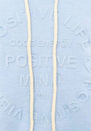 Light blue fabric with embossed text reading "GOOD ENERGY POSITIVE MIND CLUB" and cream-colored drawstrings.