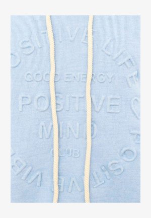 Light blue fabric with embossed text reading "GOOD ENERGY POSITIVE MIND CLUB" and cream-colored drawstrings.
