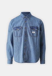 Denimhemd mit langen Ärmeln, blassblauer Farbe, zwei vorderen Taschen, Punktkragen und Knöpfen auf der Vorderseite. Etikett an der linken Tasche.