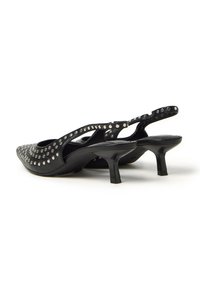 Scarpe con tacco slingback in pelle nera con tacco kitten basso e borchie argentate rotonde che decorano uniformemente le fascette e la parte superiore anteriore.