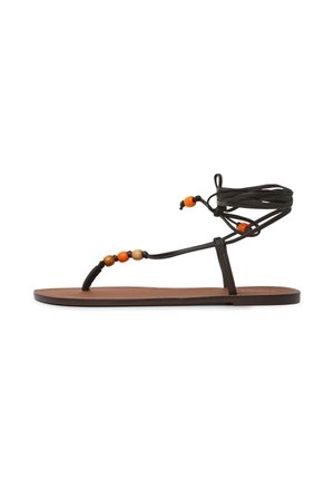 Sandalo piatto marrone con sottili cinturini neri, decorato con perline arancioni e beige, e lacci da annodare alla caviglia.