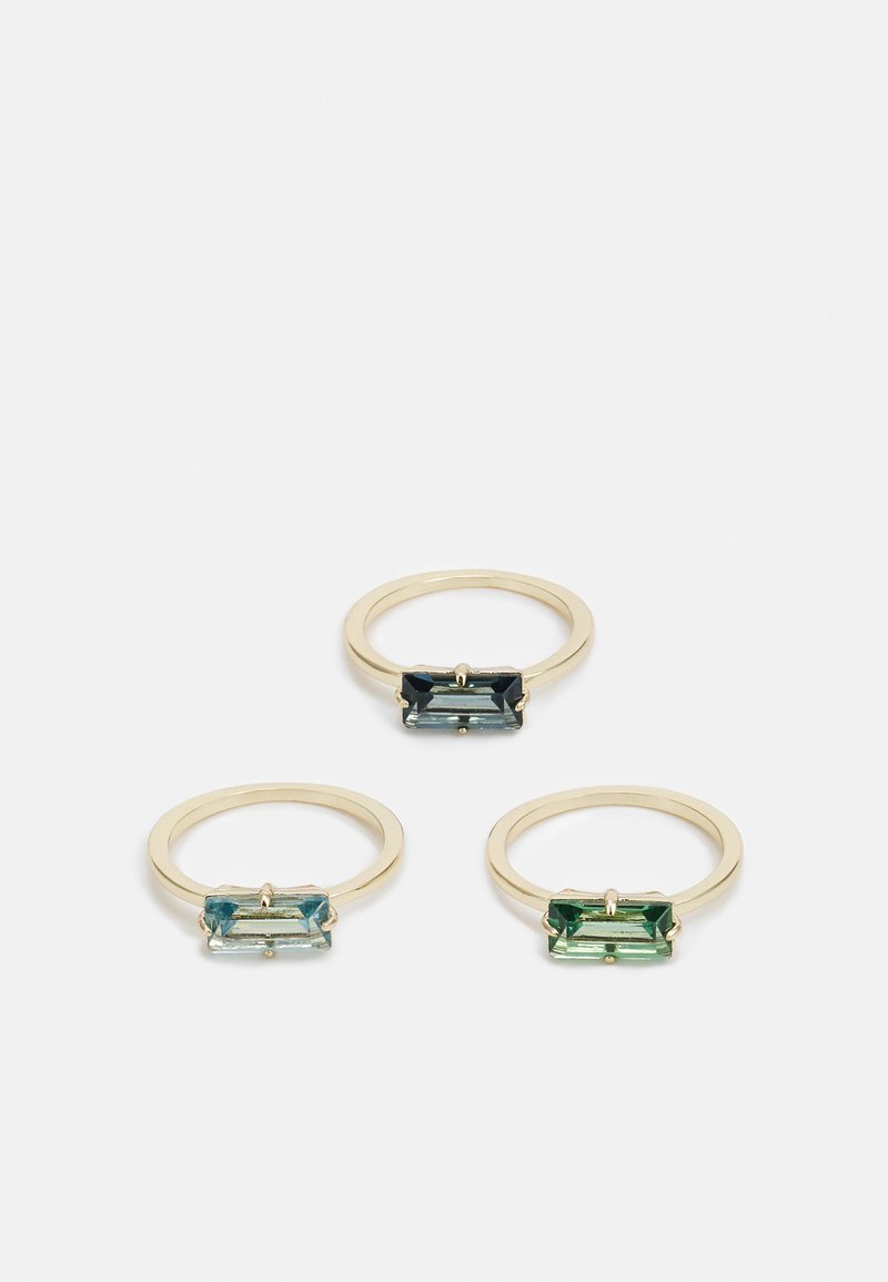 Trium zlatých prsteňov s obdĺžnikovými drahými kameňmi v svetlomodrej, tmavomodrej a zelenej farbe. Obrúčky sú hladké a jednoduché v dizajne.