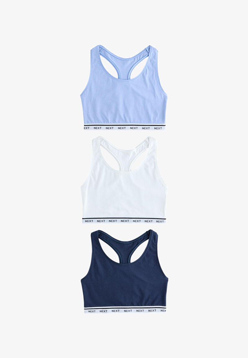 Drei Racerback-Sport-BHs in Hellblau, Weiß und Navy, jeweils mit einem weißen elastischen Band mit der Beschriftung "NEXT" am unteren Rand.