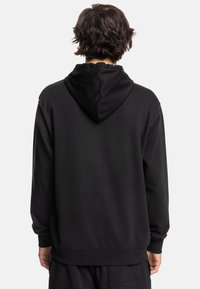 Sudadera negra con textura suave, capucha ajustable con cordón, puños y dobladillo acanalados, que presenta una parte posterior lisa sin marcas ni detalles visibles.