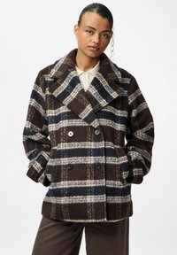 Cappotto doppiopetto in misto lana a motivi scozzesi marrone e blu con ampi risvolti e dettagli di bottoni. Presenta una finitura morbida e testurizzata.