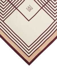 Svila šal z vanjo kremne barve in burgundskimi diagonálnimi črtami ter subtilnim logotipom. Robovi prehajajo v mehak breskvin ton. Elegantna geometrijska zasnova.