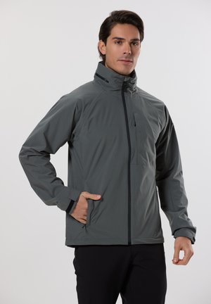 Chaqueta ligera gris para hombre con cuello alto, cierre delantero con cremallera y bolsillos laterales. Textura suave con detalles de diseño minimalistas.