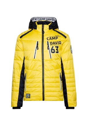 Yellow quilted jacket with black accents, zippered pockets, high collar, and logo detailing. Features a hood and ribbed cuffs.