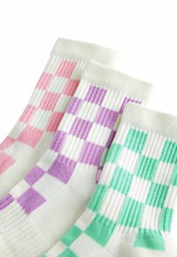 Tre par ankelsockar med ett rutmönster i rosa, lila och grönt på en vit bakgrund, med ribbade muddar.