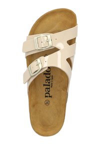 Sandales beiges avec deux brides brillantes, boucles carrées et une semelle intérieure texturée marron. Marque "Palado" sur la semelle. Design à semelle plate.