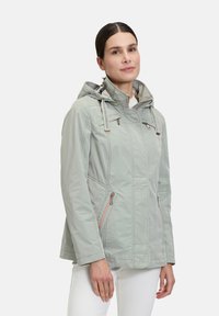 Light grey, lightweight jacket with zippered pockets, adjustable hood, and textured details on shoulders. Smooth, water-resistant fabric.