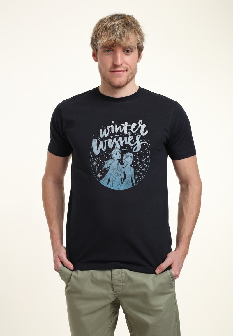 Camiseta de algodón negra con un gráfico de temática invernal que presenta dos personajes en azul, rodeados de copos de nieve blancos, y el texto "Deseos de Invierno".