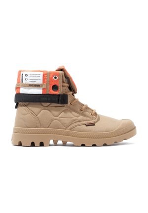 Botte montante beige en tissu texturé, avec une sangle orange et noire, semelle en caoutchouc dotée de crampons, et un design multi-texturé.