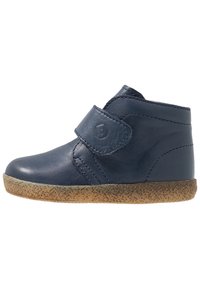 Stivale alla caviglia blu in pelle con forma curva, cinturino in velcro regolabile e suola in gomma testurizzata. Finitura liscia con dettagli di cucitura minimi.