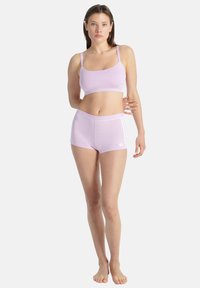 Sada lila sportovního crop topu a šortek, s tenkými ramínky, tapered střihem a bílými akcenty. Hladká textura, lehká látka.