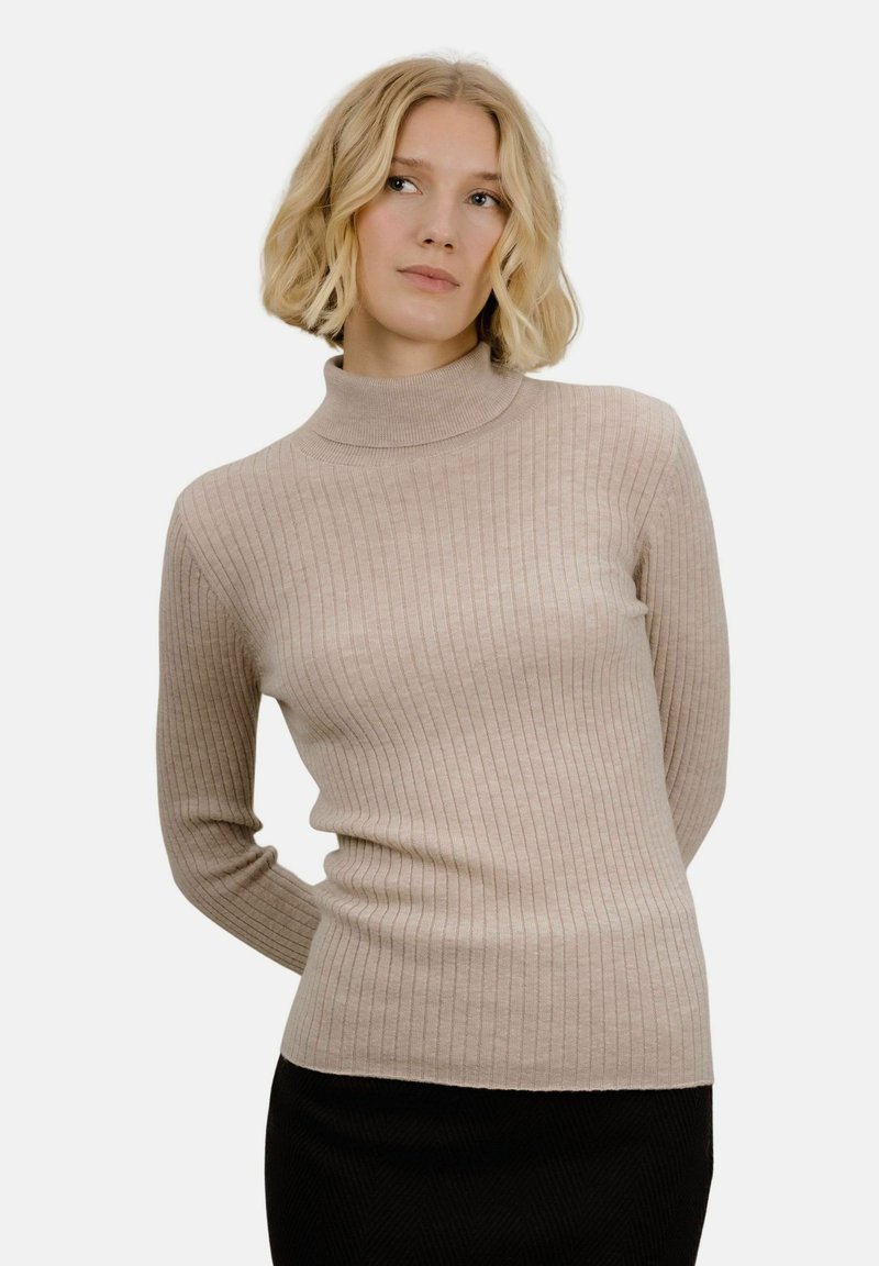 Beige ribbestrikket høyhalset genser med lange ermer, laget av myk, teksturert materiale. Innsemmingens design fremhever formen uten ekstra detaljer.