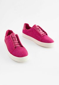 Zapatillas rosas hechas de un tejido texturizado con parte superior suave, con cordones planos y suela de goma blanca. Los acentos brillantes añaden detalle.