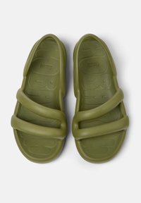 Olive green sandals made of flexible rubber material, featuring two wide straps and textured soles with a patterned grip design.