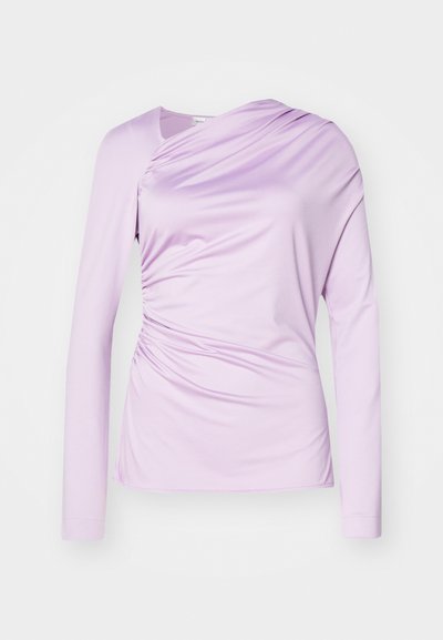 Long-sleeved top in light lavender, made of smooth fabric. Features a draped design with gathering at the side for texture detail.