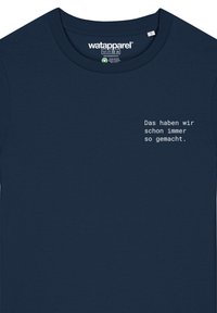 Marineblauw katoenen T-shirt met een ronde hals en korte mouwen. Witte tekstafbeelding met de tekst "Das haben wir schon immer so gemacht."