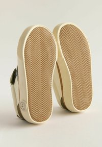 Hvide og grønne sneakers med en tekstureret gummisål. Fiskebensmønster på bunden, med en glat overdel og velcro-lukning.