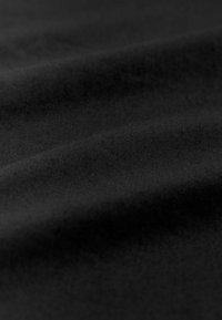 Tela negra de textura suave, con líneas diagonales sutiles y pliegues suaves, que indican un material ligero y flexible.