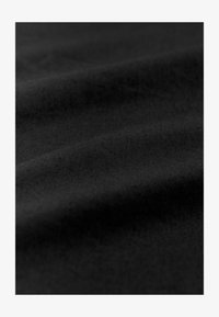 Tela negra de textura suave, con líneas diagonales sutiles y pliegues suaves, que indican un material ligero y flexible.