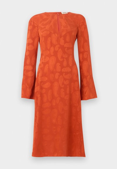 Ilgam rankovėm, iki kelių ilgio oranžinė suknelė su subtiliu paisley raštu, prigludusiu liemeniu ir raktelio formos iškirpte su užtrauktuku gale.
