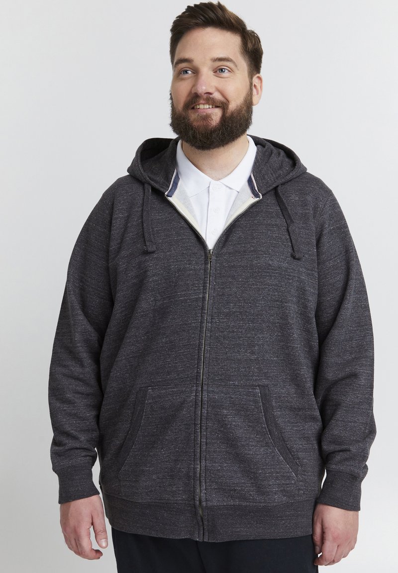 Grå zip-up hettegenser laget av teksturert stoff, med glidelås foran, snorer på hetten og store sidelommer.