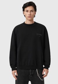 Μαύρο φούτερ από μαλακό ύφασμα, με στρογγυλή λαιμόκοψη και μακριά μανίκια. Διακριτικό λογότυπο στο στήθος και άνετη εφαρμογή. Συνδυάζεται με σκούρο τζιν.