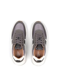 Le sneakers grigie presentano una parte superiore in mesh e pelle, punta tonda, lacci sottili e una suola bianca con accenti neri e marroni.