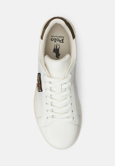 Sneaker in pelle bianca con punta rotonda, lacci piatti e design di un animale ricamato sul lato. Logo stampato all'interno. Accenti marroni.