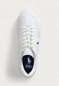 White leather sneaker with a rounded toe, lace-up design, and navy interior. Features a small blue logo on the side and textured accents.