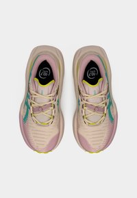 Απαλά ροζ αθλητικά παπούτσια με εμπριμέ πλέγμα στο πάνω μέρος, τυρκουάζ λεπτομέρειες, κίτρινα κορδόνια και μαλακή σόλα με ζιγκ-ζαγκ μοτίβο.