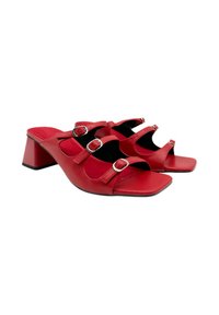 Sandalias de tacón de imitación de cuero rojo con tres correas ajustables y detalles de hebilla plateada. Punta cuadrada y un tacón bloque estable. Suela plana.