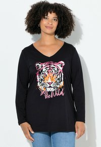 Schwarzes Langarm-T-Shirt mit V-Ausschnitt, das ein farbenfrohes Tiger-Motiv und den Text "In die Wildnis" in Pink und Orange zeigt.