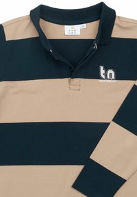 Polo majica s prugama u mornarsko plavoj i bež boji, sa ovratnikom, dugmadi i izvezenim logom "tn" s natpisom "ODUVIK."