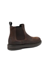 Botín Chelsea de cuero marrón con paneles elásticos en los laterales, una cinta en la parte trasera y una suela de goma negra texturizada para mayor agarre. Acabado suave y diseño clásico.