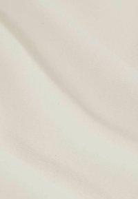 Tessuto di cotone con una superficie liscia e morbida di colore bianco sporco; presenta pieghe sottili e un motivo di tessitura uniforme.