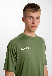 Olijfgroen sport T-shirt met korte mouwen, een ronde hals en het "hummel" logo in een lichte kleur op de borst. Soepele stoftextuur.